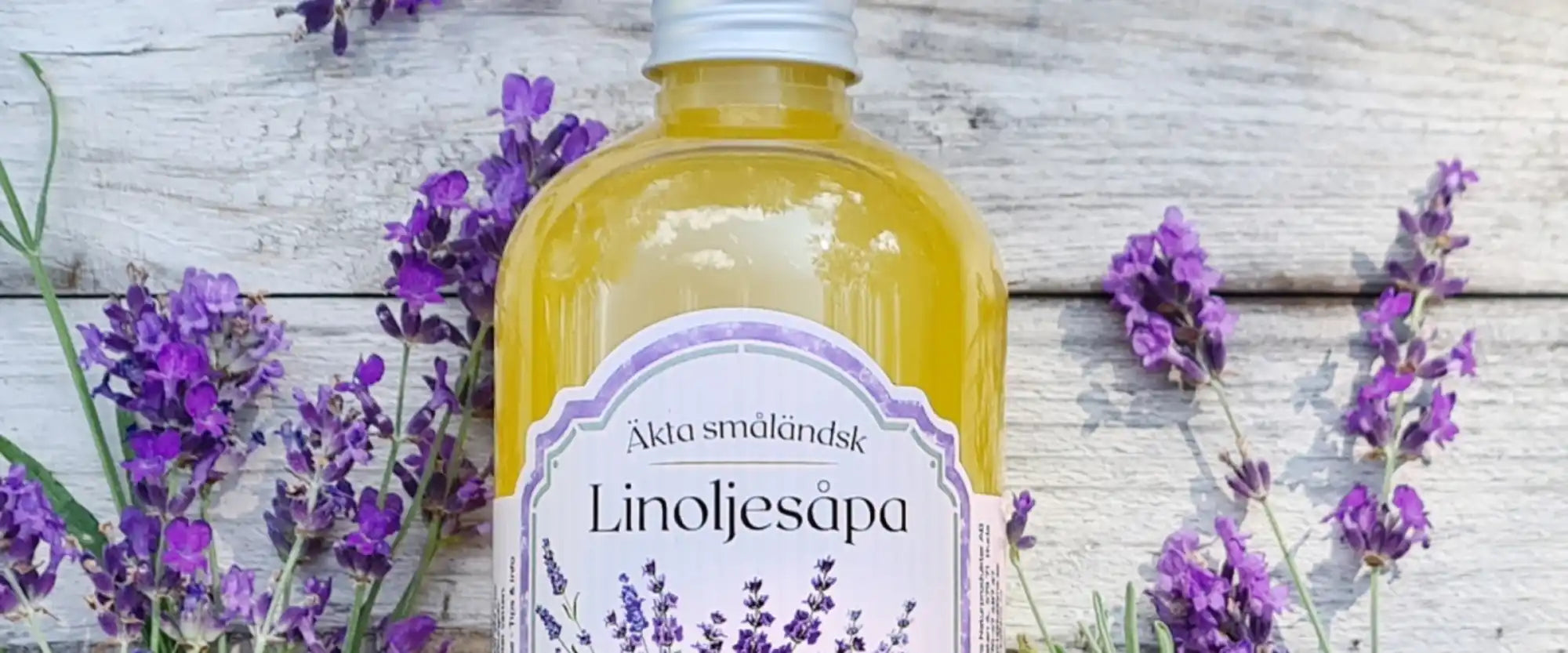 En flaska med gult flytande tvål med en lavendelfärgad etikett.