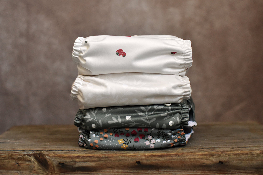 A stacked pile of Time Ahead Sweden cloth nappies on an oak bench