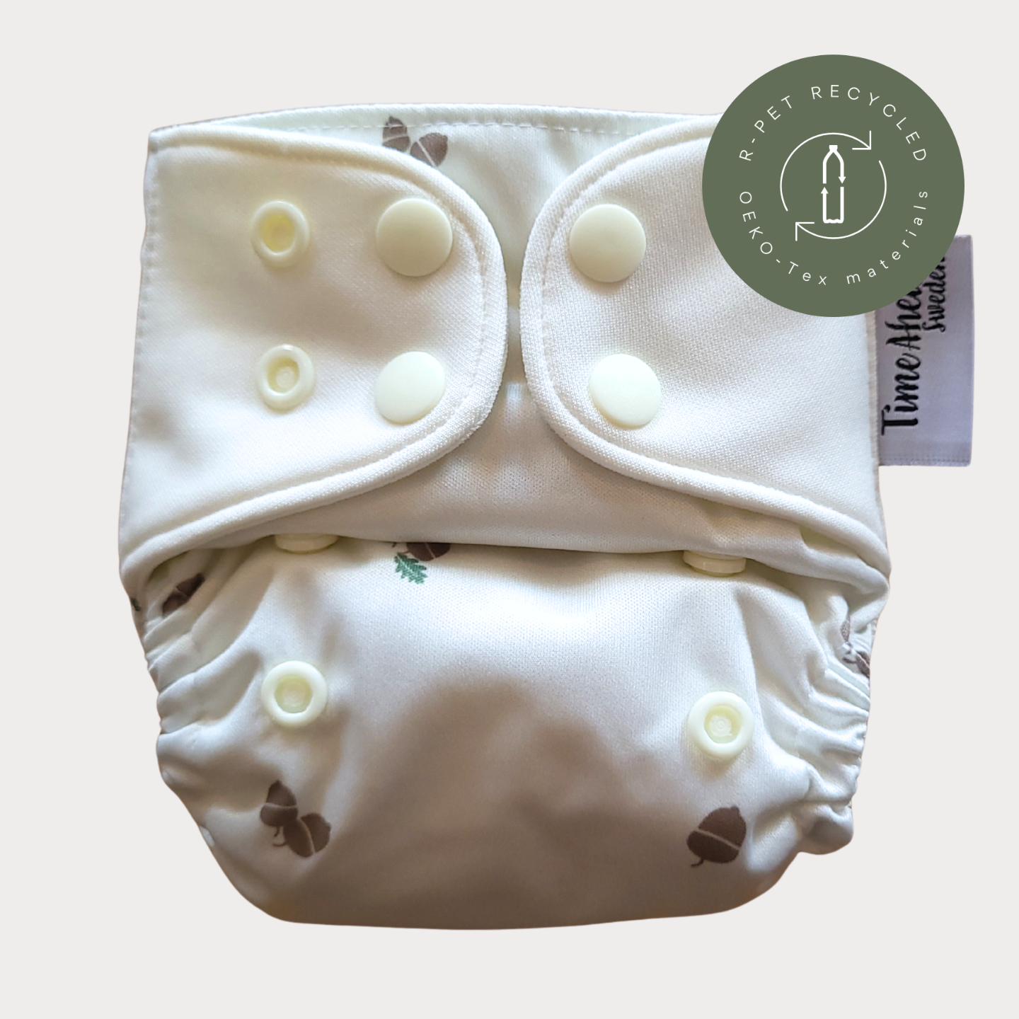 Cloth Nappy Newborn all-in-one 2–6 kg in the Ekollon pattern, shown from the front with white snap tabs.