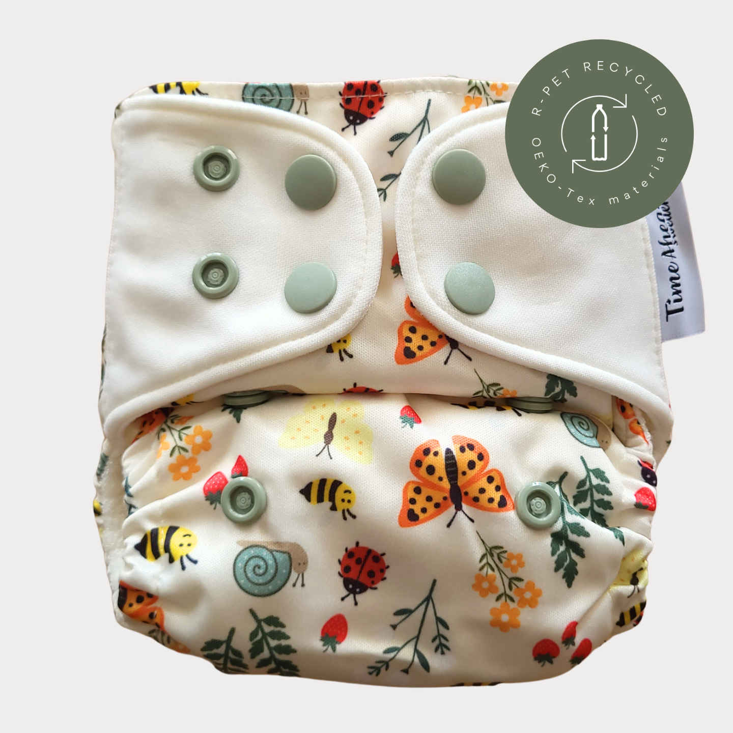 Cloth Nappy Newborn all-in-one 2–6 kg in the Ängsving pattern, shown from the front with white snap tabs.