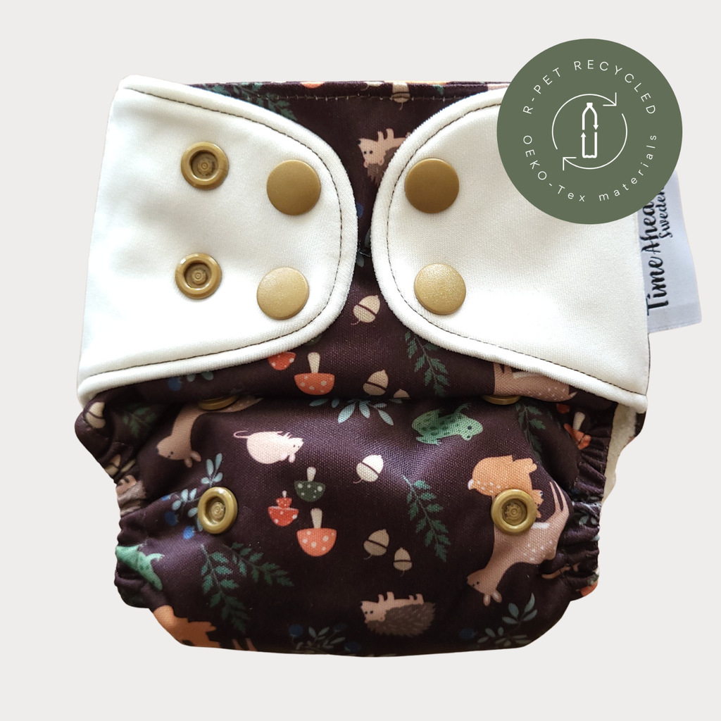 Cloth Nappy Newborn all-in-one 2–6 kg in the Skogsvrå pattern, shown from the front with white snap tabs.