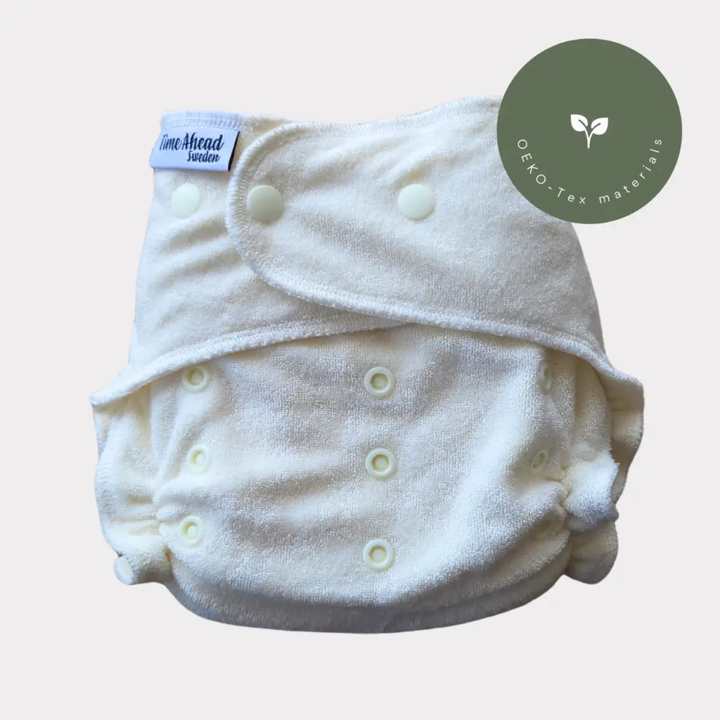 En mjuk, off-white tygblöja med texturerad yta och matchande knappfästen.