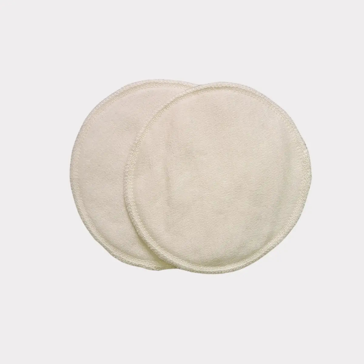 Krämfärgade amningsbindor i ekologisk bomull med texturerad ytdesign.