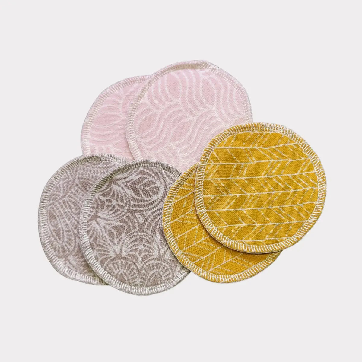 4-pack återanvändbara bambu-bomullspads med blommiga och geometriska mönster i rosa, grått, vitt, gult.