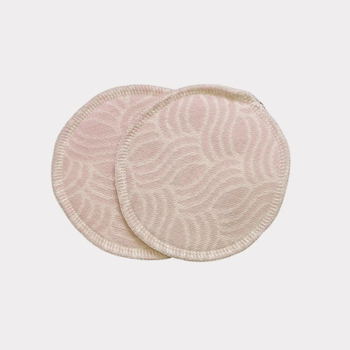 Krämfärgade cirkulära återanvändbara bomullsrondeller med ett texturerat mönster och vågade kanter.