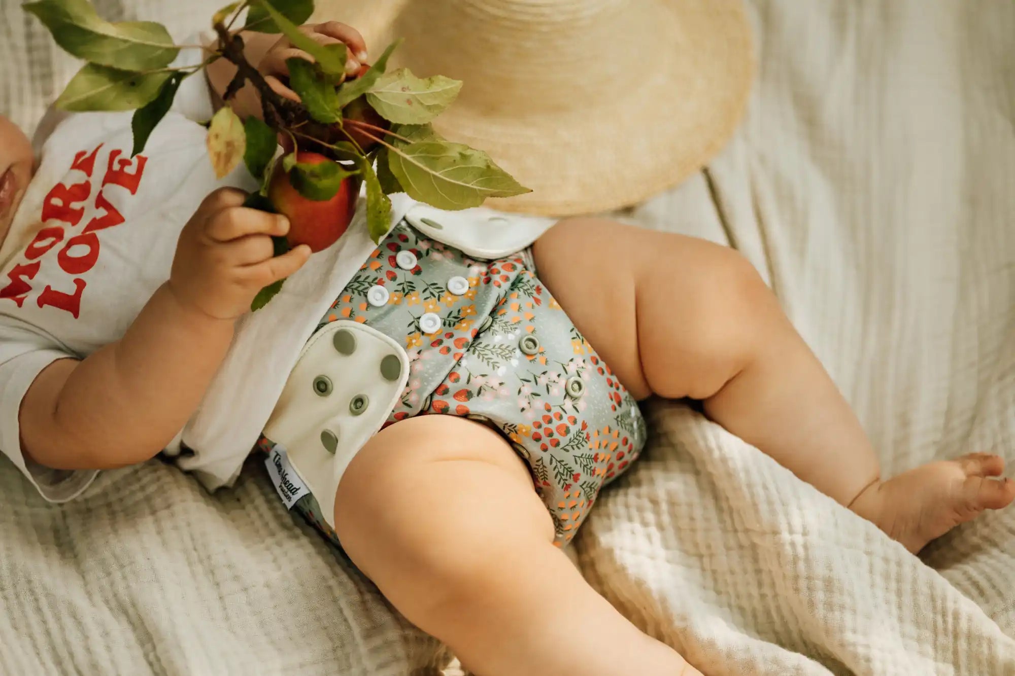 En bebis som bär en blommig tygblöja.