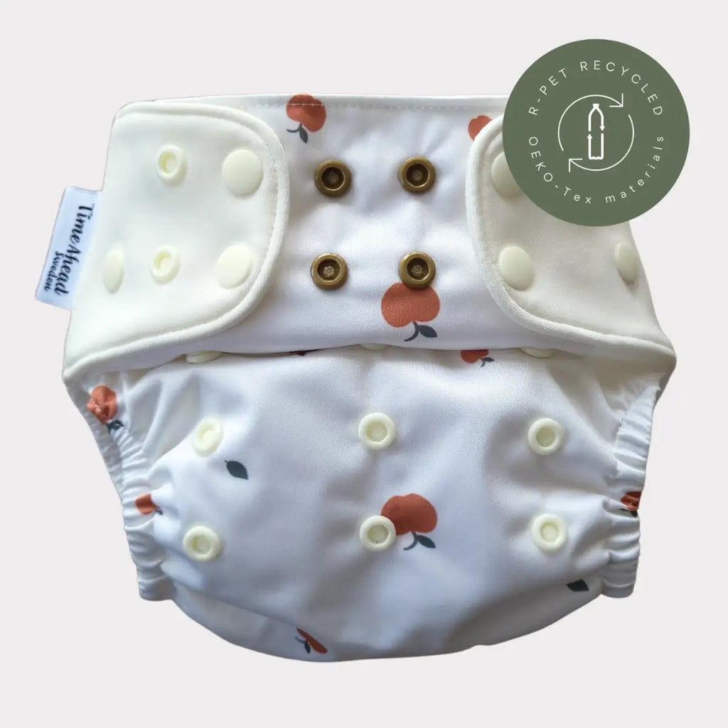 Tygblöja Komfort 5–17 kg i mönstret Äpple, vit, sedd framifrån.
