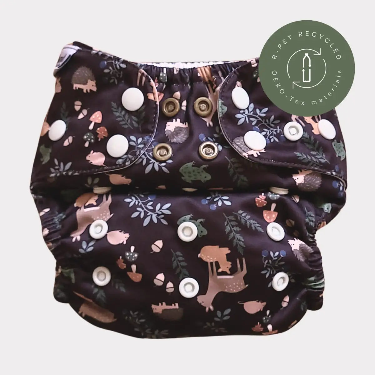 Mörk marinblå tygblöja med ett whimsiskt skogsmönster som inkluderar rosa och beige djur, svampar, ekollon och löv på en mjuk tygyta.