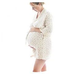 En gravid kvinna i blomstrande morgonrock som mammor delar i artikeln om förlossningsberättelser