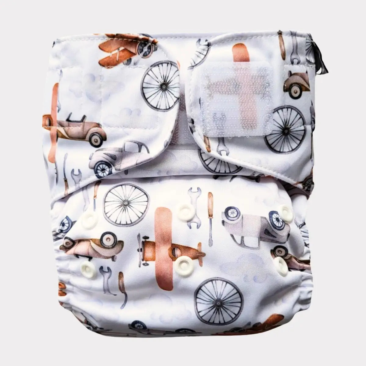 Vit tygblöja med vintagebil- och flygplansmönster i bruna, svarta och beige toner
