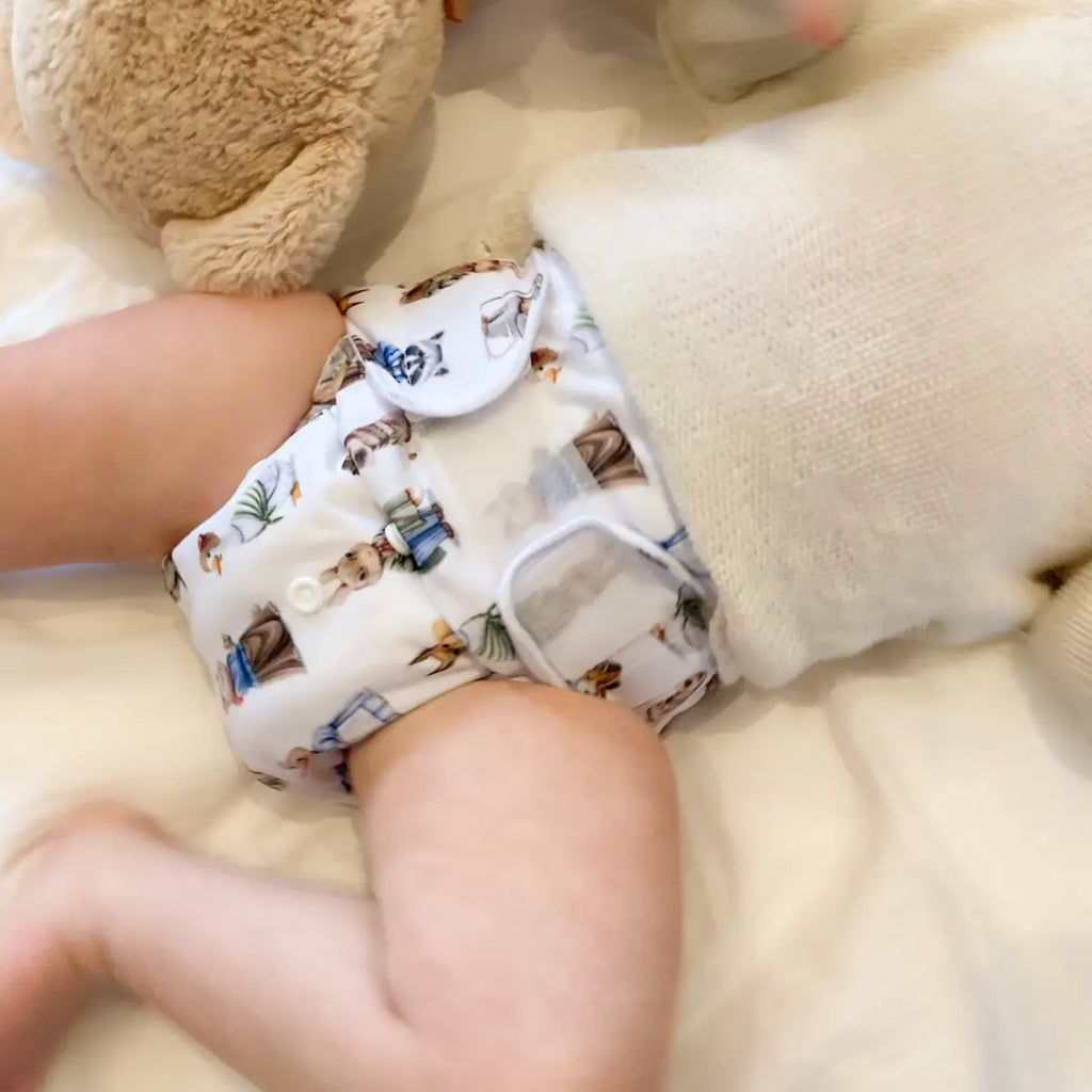 Tygblöja med ett sött djurmönster som bärs av en baby.