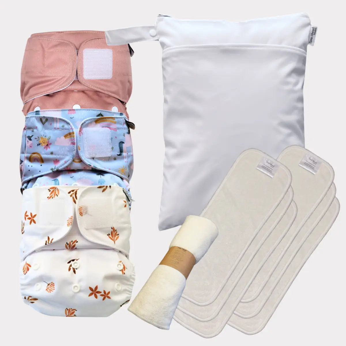 Återanvändbart tygblöjs-set med färgglada mönster och vattentätt foder, inklusive en vit förvaringsväska.