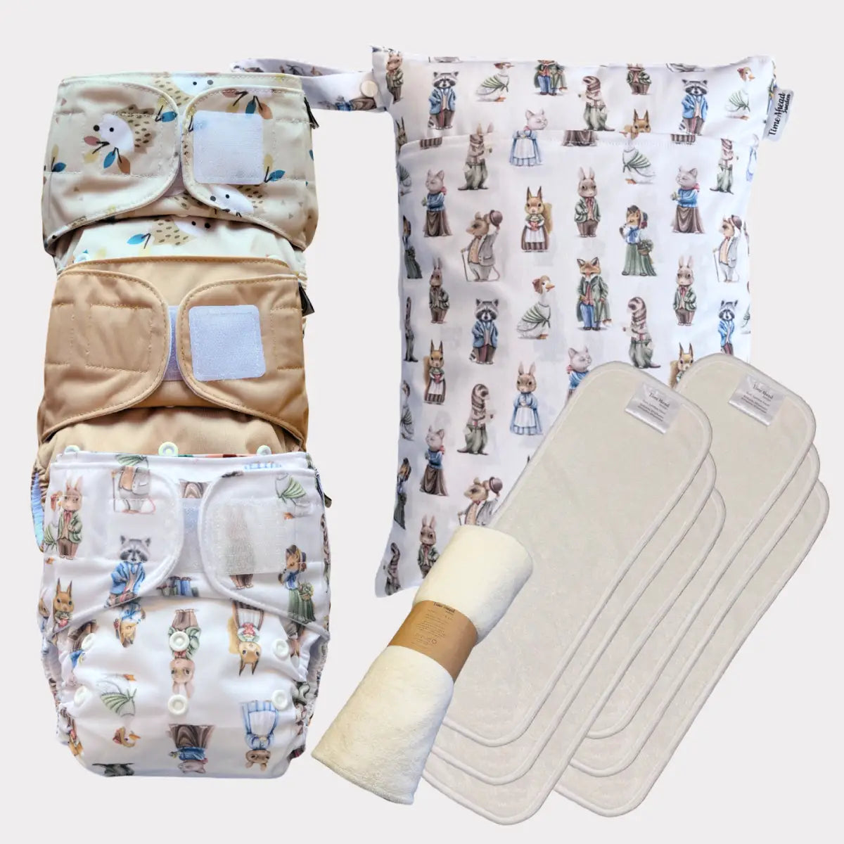 Ett set med tre tygblöjor med ett lekfullt djurtryck, med beige och vit tyg med mjuka knappstängningar.