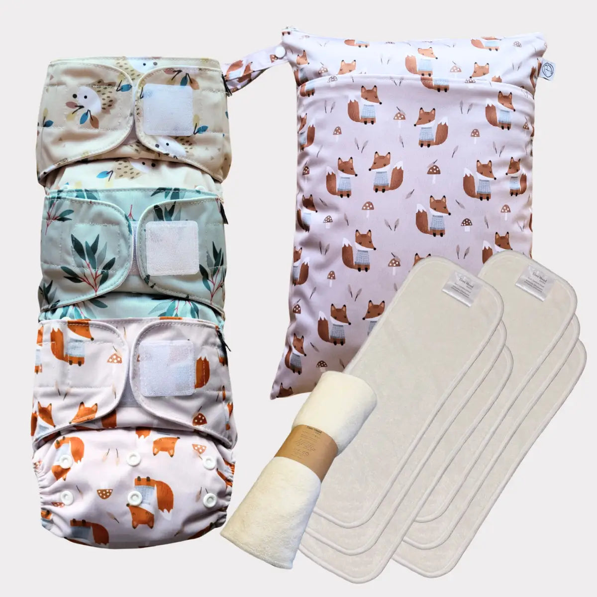 Sats med tre mönstrade tygblöjor med matchande vattentät väska med räv-tema och absorberande insatser.