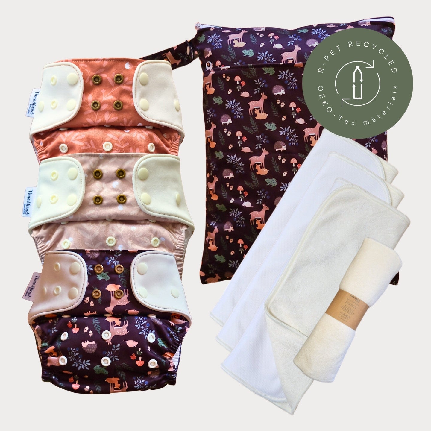 Tre tygblöjor i mönstren Humleblomster koppar, Humleblomster beige och Skogsvrå med en matchande wetbag i Skogsvrå och tre vita inlägg.