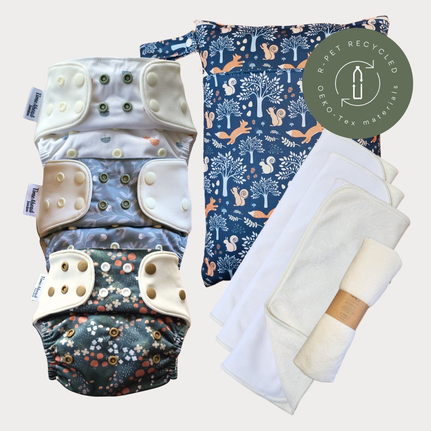 Tre tygblöjor i mönstren Skogssvamp, Humleblomster blå och Dalaskog med en wetbag i Dalaräv och tre vita inlägg.