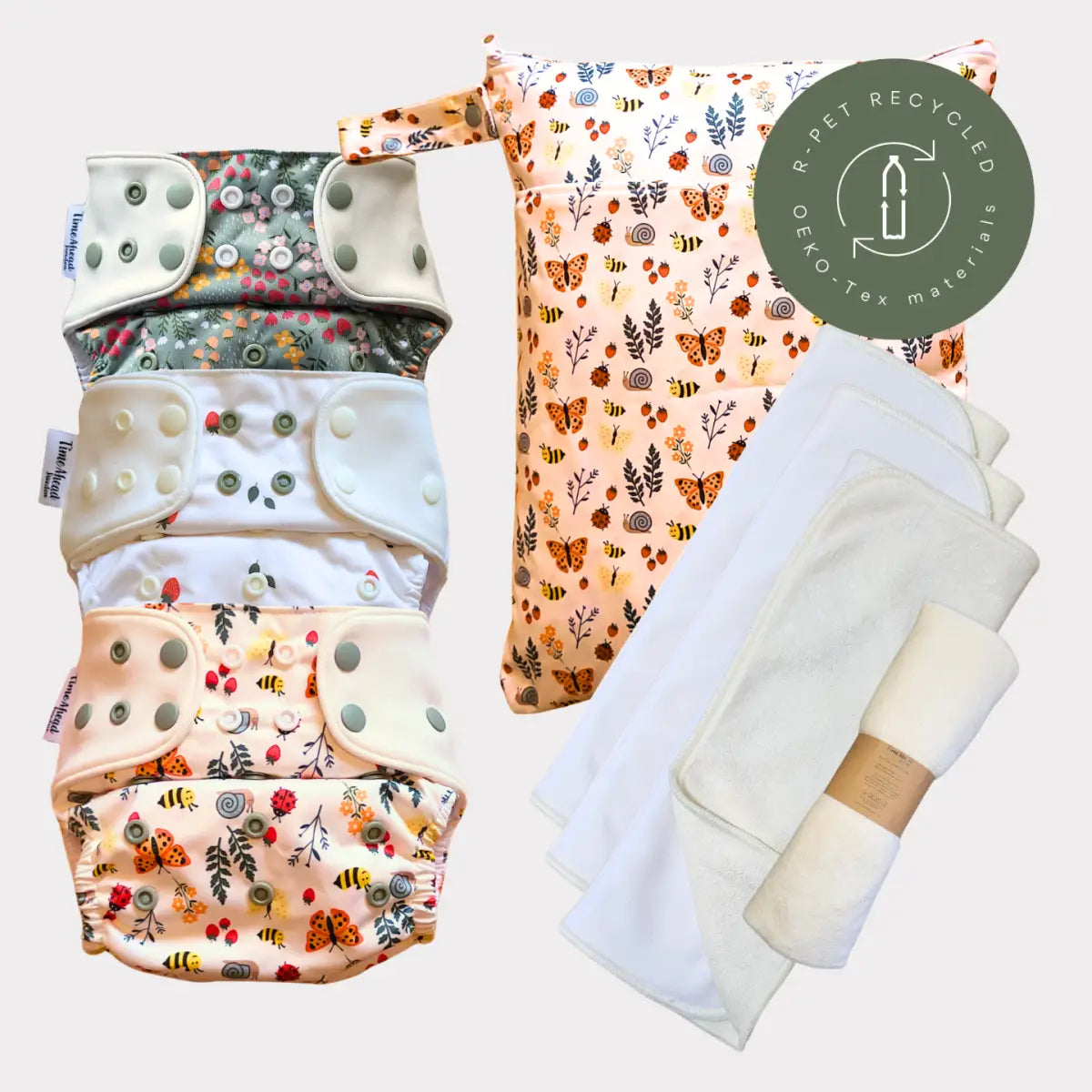 En mjuk persikofärgad återanvändbar tygblöja med ett charmigt mönster av fjärilar, bin och löv.