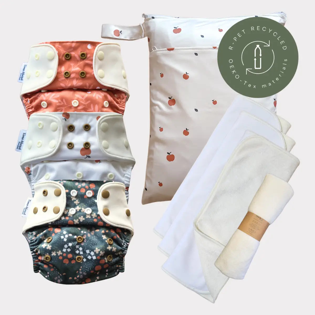 Sats med tre återanvändbara tygblöjor med blommönster och tryckknäppningar, i korall, vit och grön design.