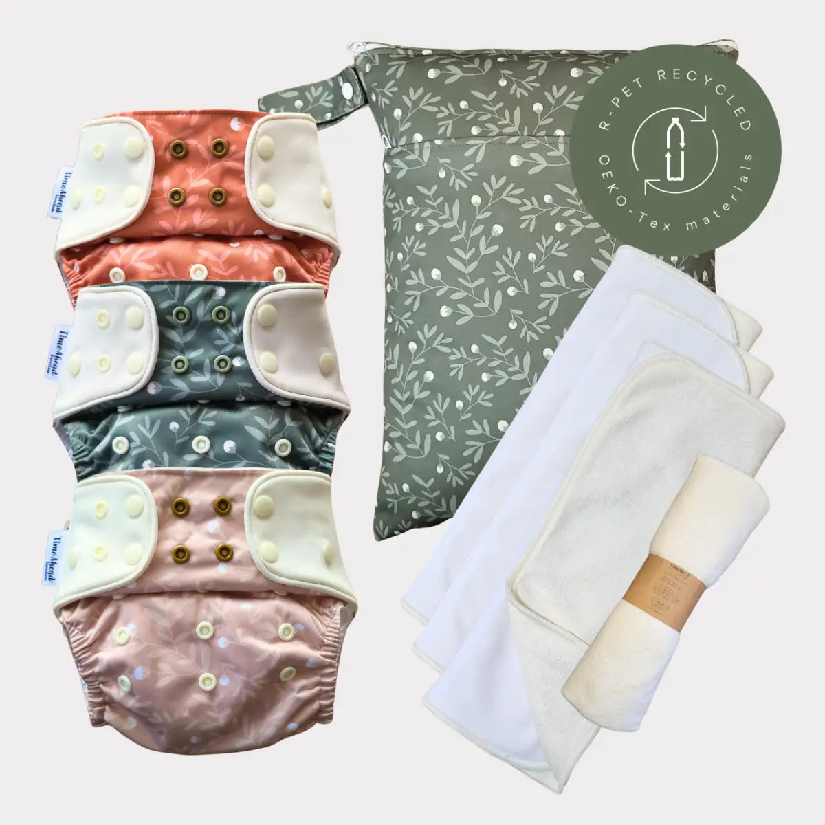 Sats med fyra återanvändbara tygblöjor i mjuka pastellfärger med tryckknäppningar och matchande mönstrad förvaringsväska.