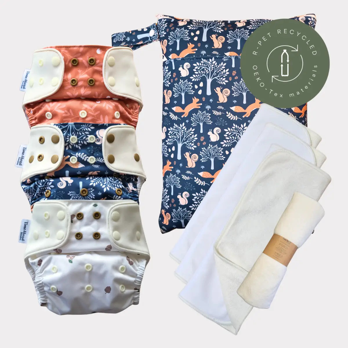 Sats med tre tygblöjor med knäppningsstängningar i korall-, marinblå och vita mönster.