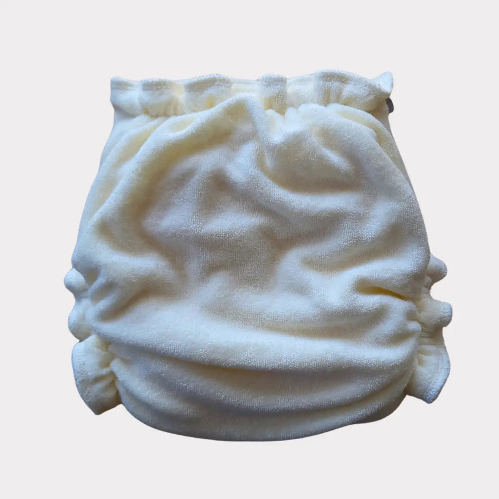 Mjuk, krämfärgad tygblöja med elastiska ben- och midjeöppningar.
