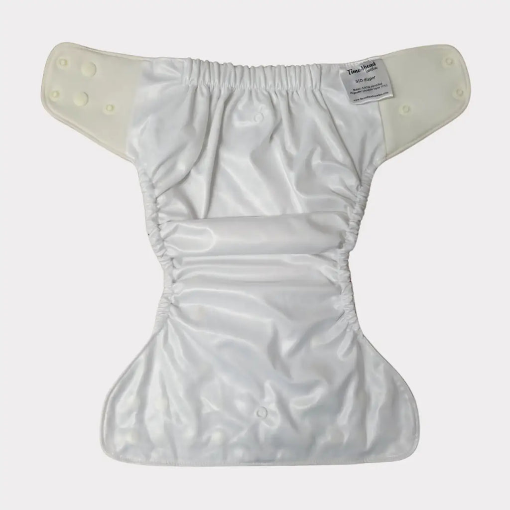 Vit tygblöja med tryckknappar.