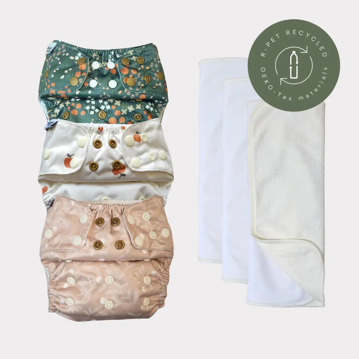 Miljövänliga återanvändbara tygblöjor med färgglada blommönster och knappar, tillverkade av återvunna material.