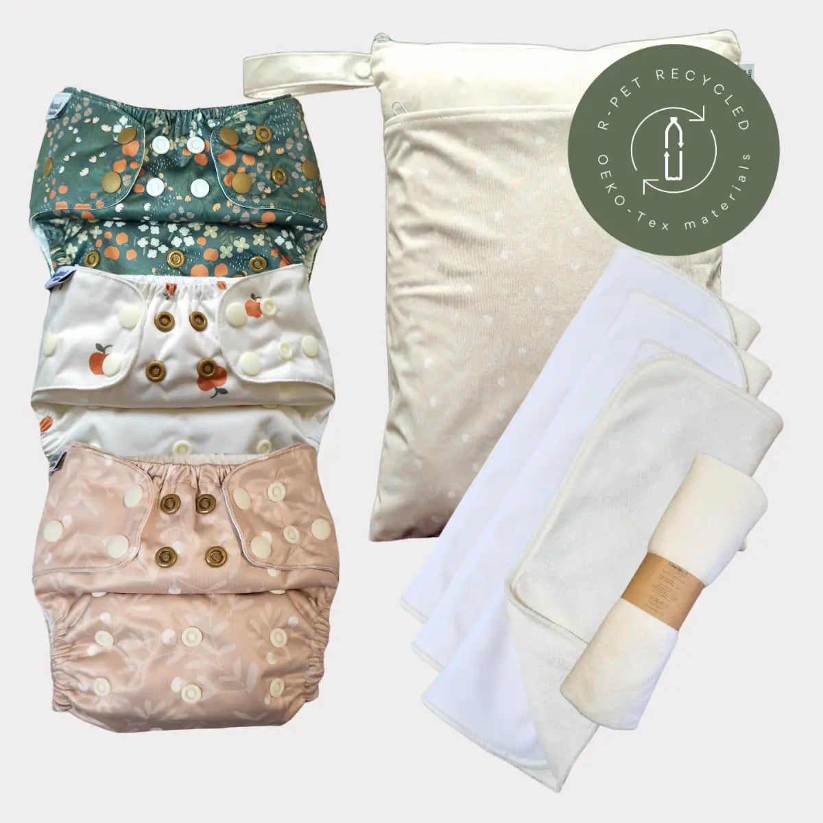 Miljövänligt blöjset med återanvändbara tygblöjor och inlägg i pastellblommiga mönster, tillverkade av återvunna material.