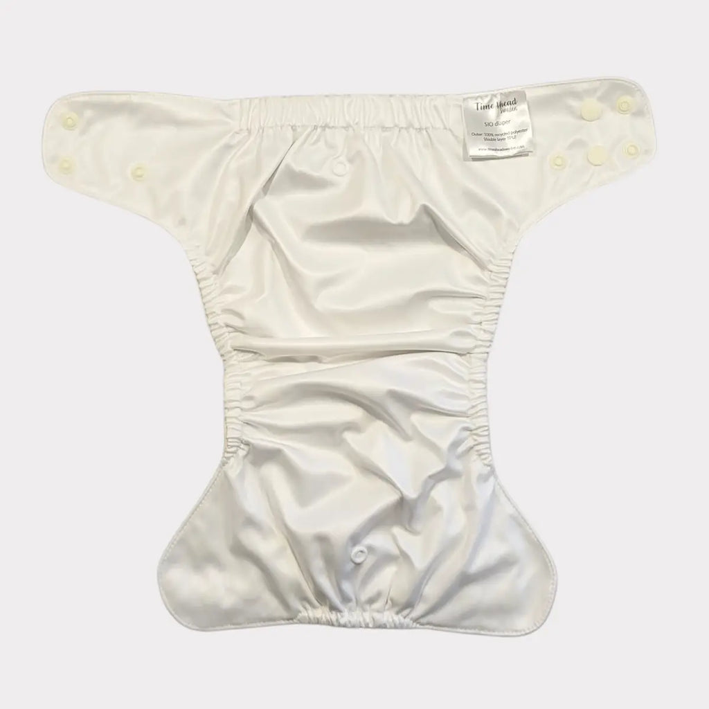 Tygblöja med elastiska kanter och en etikett fäst vid blöjan.