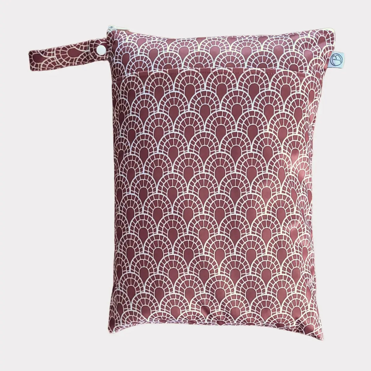 En mörkröd och vit mönstrad återanvändbar blöjväska med ett vågigt bågformat utseende.